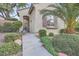 Inviting home entrance with landscaped steps and a decorative iron security door, surrounded by lush, manicured greenery at 11345 Espadrille Ct, Las Vegas, NV 89138