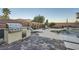 Spacious backyard boasting a built-in outdoor kitchen, BBQ grill, pool, spa, and a lovely stone patio area at 11345 Espadrille Ct, Las Vegas, NV 89138