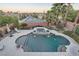 Backyard with a custom pool and hot tub, lush landscaping, and scenic neighborhood views at 11345 Espadrille Ct, Las Vegas, NV 89138