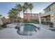 Lush backyard with a stunning pool, spa, mature palm trees, and a manicured lawn for exceptional outdoor enjoyment at 11345 Espadrille Ct, Las Vegas, NV 89138