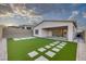 Backyard boasts artificial turf, decorative pavers, and a covered patio area for relaxation at 11617 Peregrine Point Ct, Las Vegas, NV 89138