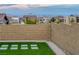 Home with a well-kept artificial turf backyard and brick perimeter wall with a distant city view at 11617 Peregrine Point Ct, Las Vegas, NV 89138