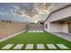 Spacious backyard featuring artificial grass, modern pavers, and block wall fencing at 11617 Peregrine Point Ct, Las Vegas, NV 89138