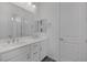 Modern bathroom with dual sinks, ample lighting, white cabinetry, and a large mirror at 11617 Peregrine Point Ct, Las Vegas, NV 89138