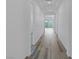 Bright hallway features modern wood-look flooring, recessed lighting, and access to various rooms within the home at 11617 Peregrine Point Ct, Las Vegas, NV 89138