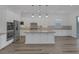 Modern kitchen with white cabinets, stainless steel appliances, pendant lighting, and a large center island at 11617 Peregrine Point Ct, Las Vegas, NV 89138
