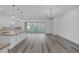 Spacious living room boasts backyard views, wood floors, and modern chandelier lighting at 11617 Peregrine Point Ct, Las Vegas, NV 89138