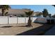 Spacious dirt backyard featuring white fencing, desert foliage, and a walkway at 1214 Emerald Stone Ave, North Las Vegas, NV 89081