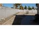 Spacious backyard featuring concrete and white fencing, rocks, and desert foliage at 1214 Emerald Stone Ave, North Las Vegas, NV 89081