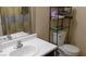 Compact bathroom with a sink, toilet, and storage shelf for toiletries and towels at 1214 Emerald Stone Ave, North Las Vegas, NV 89081