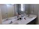 Bathroom featuring dual sinks and a large mirror at 1214 Emerald Stone Ave, North Las Vegas, NV 89081
