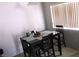 Cozy dining area with a dark wooden table set for four, illuminated by natural light at 1214 Emerald Stone Ave, North Las Vegas, NV 89081