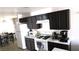 A cozy kitchen featuring dark cabinets, white appliances and countertops, and tile flooring at 1214 Emerald Stone Ave, North Las Vegas, NV 89081