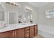 Bright bathroom features a double sink vanity, soaking tub, and large mirror at 1525 Spiced Wine Ave # 14105, Henderson, NV 89074