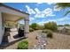 Beautiful backyard with a covered patio, a rock stream, and desert landscaping at 1613 Williamsport St, Henderson, NV 89052