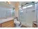 Well-lit bathroom featuring a tiled shower with glass doors, a vanity, and a toilet at 1613 Williamsport St, Henderson, NV 89052