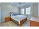 Cozy bedroom boasts wood floors, a ceiling fan, shuttered windows, and ample natural light at 1613 Williamsport St, Henderson, NV 89052