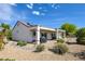 Charming home exterior with covered patio, desert landscaping, and solar panels at 1613 Williamsport St, Henderson, NV 89052