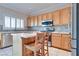 Bright kitchen with stainless steel appliances, stone backsplash, and center island with seating at 1613 Williamsport St, Henderson, NV 89052