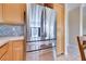Kitchen with stainless steel refrigerator, stone backsplash, and white tile flooring at 1613 Williamsport St, Henderson, NV 89052
