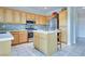 Bright kitchen featuring an island, light wood cabinets, stone countertops, and stainless appliances at 1613 Williamsport St, Henderson, NV 89052