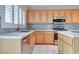 A well lit kitchen featuring stainless steel appliances, stone backsplash, and wooden cabinets at 1613 Williamsport St, Henderson, NV 89052
