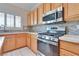 Kitchen featuring stainless steel appliances, stone backsplash, and white countertops at 1613 Williamsport St, Henderson, NV 89052
