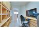 Well-lit home office features custom built-in cabinetry, tile floors, and a built-in desk at 1613 Williamsport St, Henderson, NV 89052
