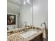 Bathroom featuring a granite countertop, decorative mirror, and a white porcelain sink at 1672 Cloister Ave, Henderson, NV 89014