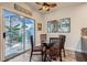 Cozy dining area with glass table and chairs, ceiling fan, and sliding glass doors to the outdoor patio at 1672 Cloister Ave, Henderson, NV 89014