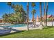 Community pool with palm trees and lounge chairs at 1672 Cloister Ave, Henderson, NV 89014