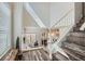 Staircase with wooden steps and white railing, leading to a bright, open living area with natural light at 1672 Cloister Ave, Henderson, NV 89014