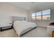 Serene bedroom featuring a cozy bed, soft carpet, bedside table, and a large window with backyard views at 168 Robledo St, Las Vegas, NV 89138