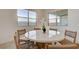 Cozy dining area with a round table, woven chairs, and natural light streaming through large windows at 168 Robledo St, Las Vegas, NV 89138