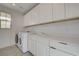Well-organized laundry room, featuring a sink, white cabinets, and modern appliances at 168 Robledo St, Las Vegas, NV 89138