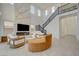 Bright living room featuring a soaring two-story ceiling, modern fireplace, and elegant staircase at 168 Robledo St, Las Vegas, NV 89138