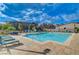 Community pool with lounge chairs and beautiful landscaping under a sunny blue sky at 168 Robledo St, Las Vegas, NV 89138
