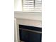 Close-up of a fireplace with white tile surround and a black firebox, underneath window at 1812 Jack Rabbit Way, Las Vegas, NV 89128