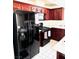Spacious kitchen featuring dark wood cabinets, stainless steel appliances, and white tile flooring at 1812 Jack Rabbit Way, Las Vegas, NV 89128