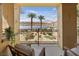 Picturesque balcony overlooking a tranquil lake with palm trees and desert landscaping at 20 Via Mantova # 208, Henderson, NV 89011