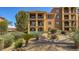 Beautiful building exterior with desert landscaping, mature trees, and scenic surroundings at 20 Via Mantova # 208, Henderson, NV 89011