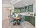 Dining area with sage green cabinets, hardwood floors, and glass-front display cabinets at 20 Via Mantova # 208, Henderson, NV 89011