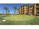 Attractive building exterior surrounded by a manicured green lawn and palm trees at 20 Via Mantova # 208, Henderson, NV 89011