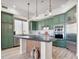 Charming kitchen with sage green cabinets, stainless steel appliances, and a center island at 20 Via Mantova # 208, Henderson, NV 89011