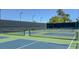 Outdoor tennis courts with a view of palm trees on a bright, sunny day at 20 Via Mantova # 208, Henderson, NV 89011