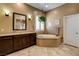 Bathroom with a tub, vanity with dark wood cabinets, and sconces at 2425 Amatrice St, Henderson, NV 89044