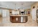 Kitchen island with bar seating, granite countertop and sink, seamlessly connecting to the open-concept living space at 2425 Amatrice St, Henderson, NV 89044