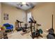 Home gym featuring various workout equipment, carpet flooring, and a ceiling fan at 2425 Amatrice St, Henderson, NV 89044