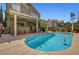 Expansive backyard with a covered patio, outdoor seating, pool, and lush landscaping at 2429 Sun Shores Dr, Las Vegas, NV 89128