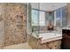 Stylish bathroom featuring a shower, bathtub with granite surround, and modern lighting at 2429 Sun Shores Dr, Las Vegas, NV 89128